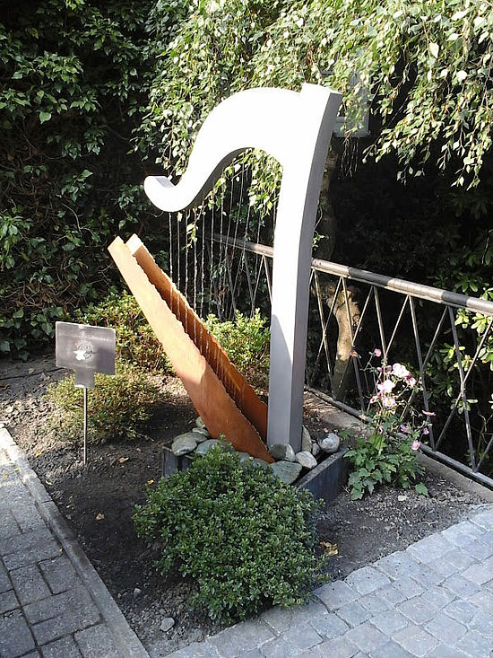 Ergänzt die Treppe: Harfen-Skulptur in einer Kombination aus Cor-Ten und Edelstahl. Foto: Dünnebacke